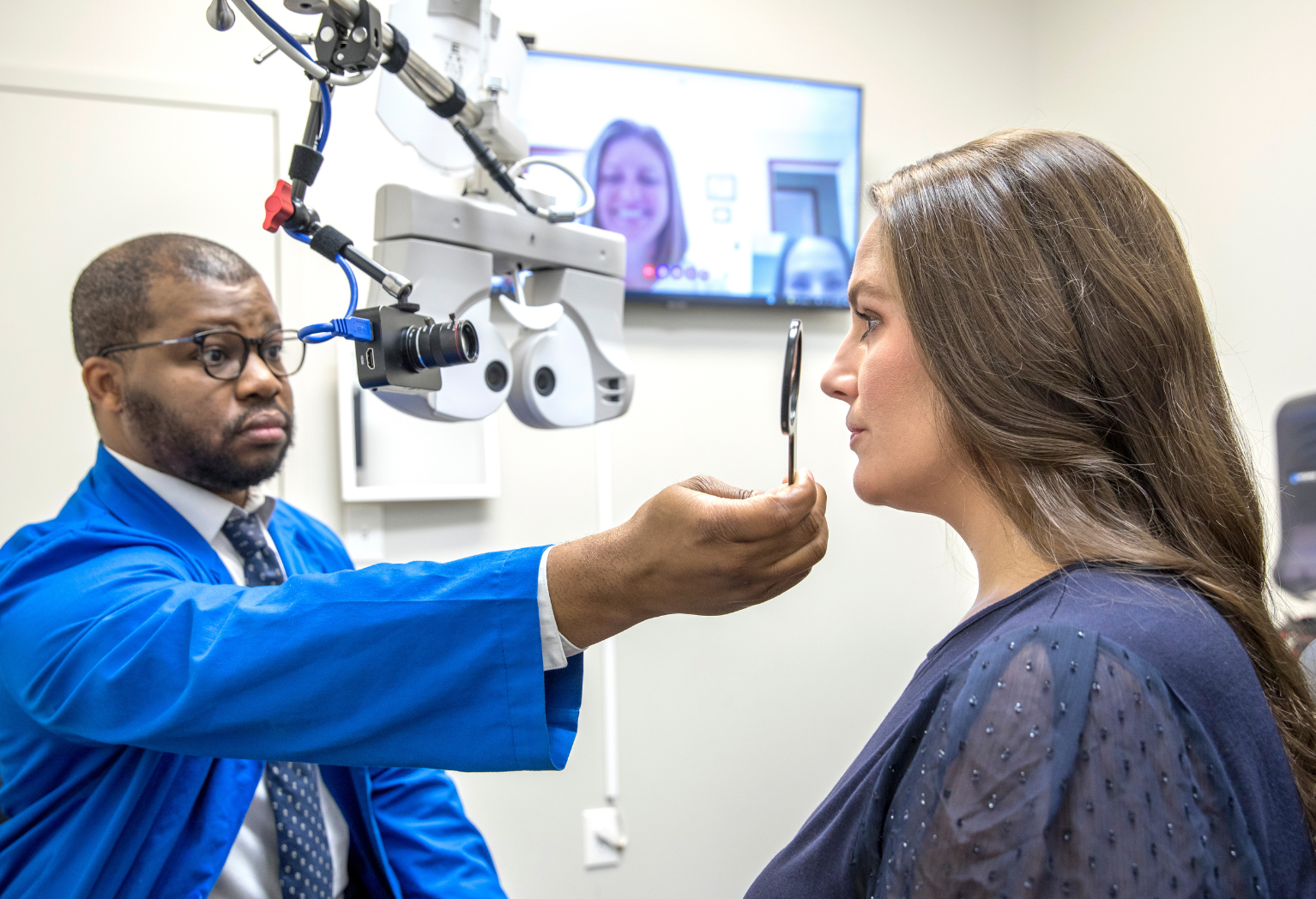 Man performing an eye exam on woman