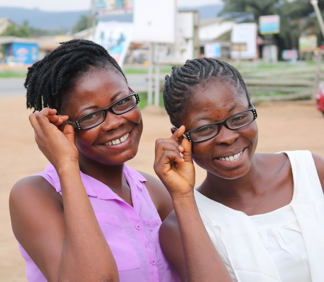 two girls smiling while wearing glasses